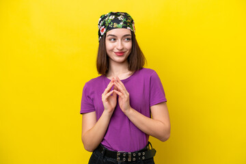 Young Ukrainian woman isolated on yellow background scheming something