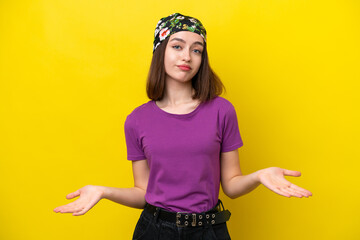 Young Ukrainian woman isolated on yellow background having doubts