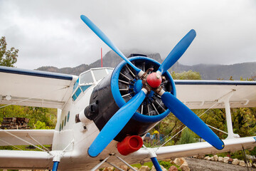 The engine and propeller of an airplane against the background of mountains on a clear sunny day. Transportation recreation sports hobbies travel