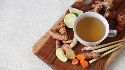 An Indonesian traditional herbal drink called rempah-rempah, or rimpang. Ginger, turmeric, galangal, lime, and lemongrass. Isolated - on grey background
