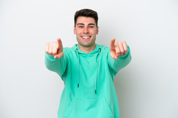 Fototapeta premium Young caucasian man isolated on white background surprised and pointing front