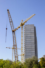 The facade of a house under construction and a construction crane