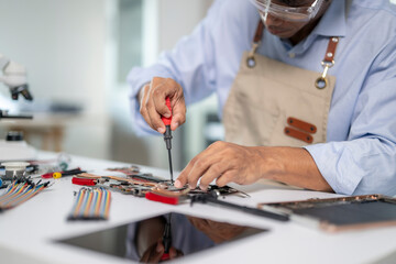 Technician repairing electronic circuit board using screwdriver
