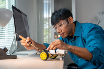 Engineer soldering components onto robot chassis in modern office
