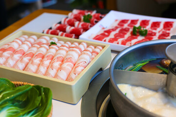 Spicy Mala hot pot with sliced meat on dining table ready to serve.

