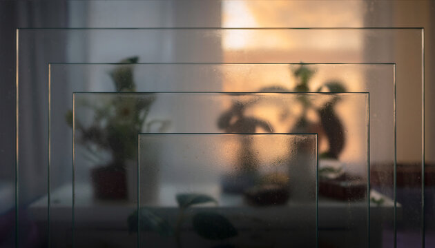 Multiple layers of translucent frosted glass or acrylic panels, creating an abstract background with depth where shapes behind are blurred.