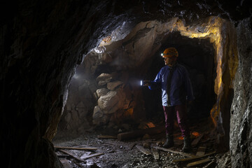 A woman walks through an abandoned magnesite mining tunnel.