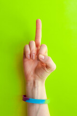 LGBT symbol -Women hand in rainbow Bracelet   shows off the middle finger, the concept of confrontation with the traditional world