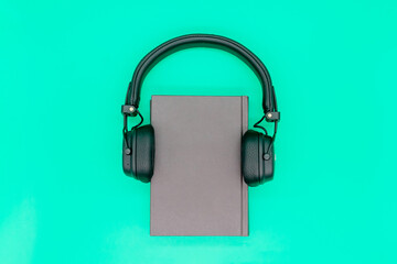 Paper book with headphones, the concept of listening to audiobooks