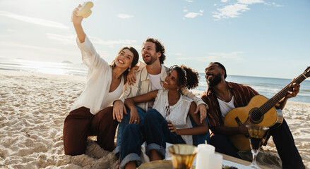 Group of friends enjoying music and taking photos on a sunny beach day