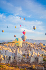A stunning sunrise landscape in Cappadocia, Turkey, showcasing colorful hot air balloons drifting above the region&rsquo;s iconic fairy chimneys and dramatic rock formations