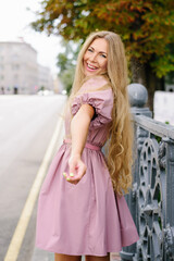 Fototapeta premium Playful Woman In Pink Dress Reaching Out