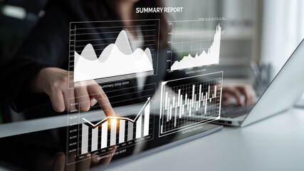 A business professional engages in financial analysis with interactive charts and graphs on a...