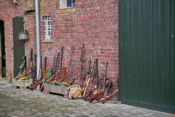 hunting guns against an old brick wall