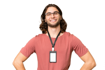 Young handsome man with ID card over isolated background posing with arms at hip and smiling