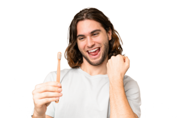 Young handsome man brushing teeth over isolated background celebrating a victory
