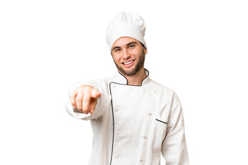 Young handsome chef man over isolated background points finger at you with a confident expression
