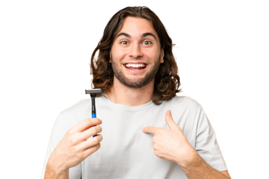 Young handsome man shaving his beard over isolated background with surprise facial expression