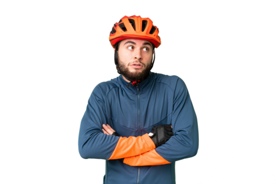 Young cyclist man over isolated chroma key background making doubts gesture while lifting the shoulders