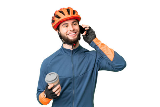Young cyclist man over isolated chroma key background holding coffee to take away and a mobile