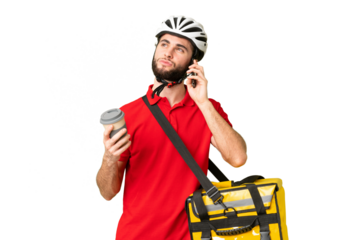 Young delivery man with thermal backpack over isolated chroma key background holding coffee to take away and a mobile