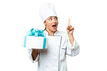 Woman pastry chef with a big cake intending to realizes the solution while lifting a finger up