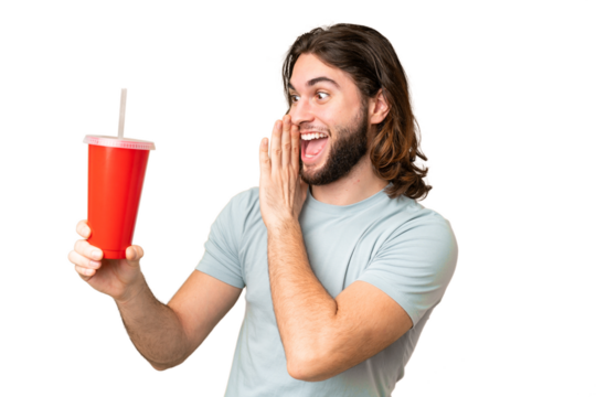 Young handsome man holding soda over isolated chroma key background with surprise and shocked facial expression