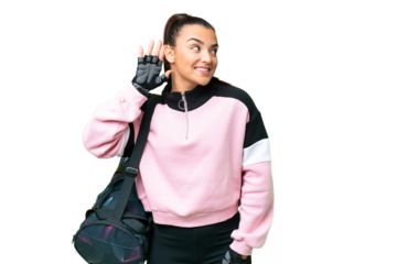 Young sport woman with sport bag over isolated chroma key background listening to something by putting hand on the ear