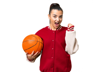 Young Woman playing basketball over isolated chroma key background celebrating a victory in winner position