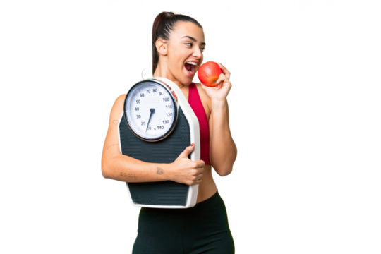 Young beauty woman over isolated chroma key background with weighing machine and with an apple - Powered by Adobe