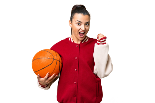 Young Woman playing basketball over isolated chroma key background celebrating a victory in winner position