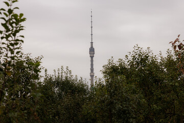 Moscow skyline reveals a towering structure amidst lush greenery on a cloudy day