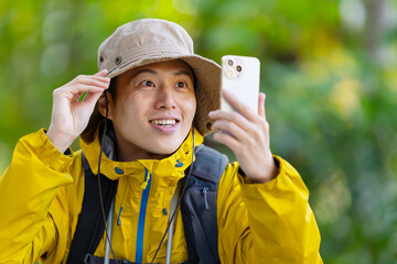 スマートフォンを使う男性　山登り　登山　ハイキング