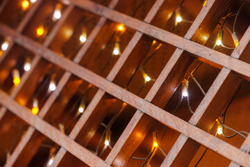 String lights illuminate wooden lattice in a cozy indoor setting during the evening