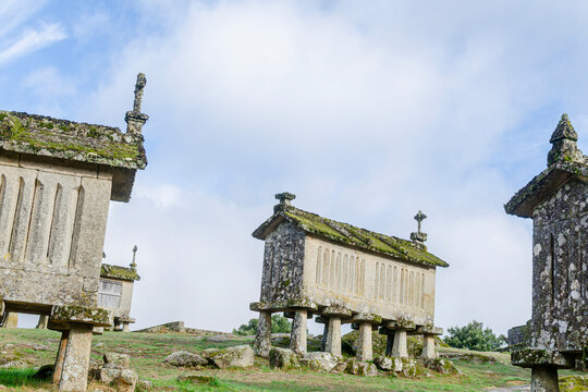 Low angle view of stone granaries against a blue sky