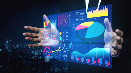 A businessman showcases virtual data analytics graphics on a transparent screen. The scene captures an urban environment at night, reflecting innovation in business presentation and technology. Impute