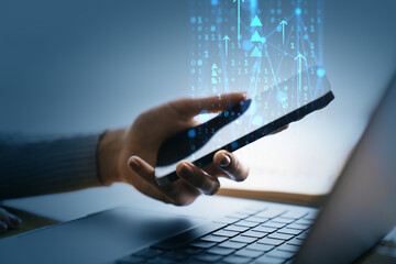 Person holding smartphone near laptop with digital data graphics and binary code overlay representing internet technology and online network concept.