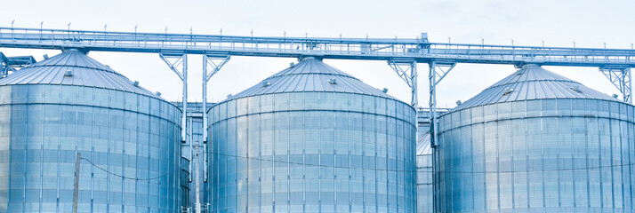 Fototapeta premium Grain silos storing agricultural harvest on a farm industry background