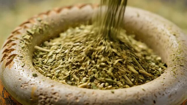 Abstract macro texture shot of finely ground dry yerba mate herb leaves slowly accumulating inside a carved traditional calabash gourd vessel herb, earthy, culinary