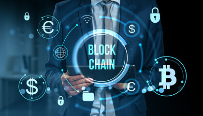 Businessman using digital tablet with blockchain cryptocurrency icons over abstract financial technology interface background in blue tones.