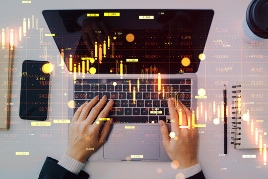 Business person typing on laptop with stock market crash data and falling graph overlay on abstract light background during financial crisis.