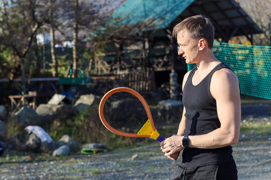 Athletic man holding racket looking sideways