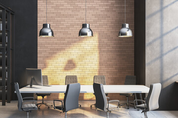 Modern office meeting room with brick wall, sunlight casting abstract shadow, and stylish chairs around white desk under industrial pendant lights. 3D Rendering