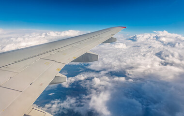 Obraz premium View from the airplane window at a beautiful cloudy sky and the airplane wing