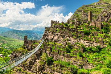 Modern mountain suspension bridge leading to the ruins of the village of Kakhib. North Caucasus