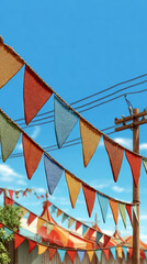 Colorful Triangle Bunting Flags Hanging Outdoors Against a Clear Blue Sky at a Fair