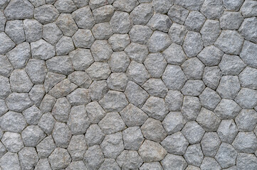 Textured gray stone wall with interlocking hexagonal pattern