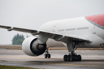 Wing and turbofan engine mounted under large aircraft on taxiway