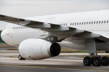 Wing and jet engine wide body aircraft on taxiway