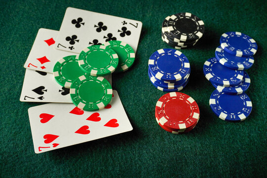 Colorful poker chips sit next to playing cards on a green felt surface, creating a lively atmosphere for a fun game night among friends. Excitement fills the air as players strategize